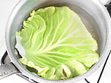 鍋にたっぷりの湯を沸かし、キャベツの葉を茹でる。茹で上ったら水にさらし、冷やす。
