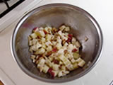 ボウルにカマンベール、りんごを入れ、オリーブオイルを加えて混ぜる。さらにナッツ類を加えて混ぜる。