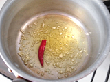 鍋にオリーブオイル、鷹の爪、ニンニクのみじん切りを入れ、弱火にかける。 ニンニクが色づき、香りが出てきたところで玉ねぎのスライスを入れ、きつね色になるまで炒める。