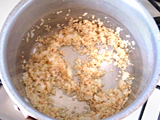 鍋にオリーブオイルと玉ねぎのみじん切りを入れ、火にかける。玉ねぎがしんなりしてきたら、玄米を加え、弱火で1分程度炒める。  ※玄米は研がずに加えること。