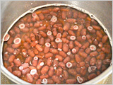 小豆を鍋に戻し、またかぶるくらいの水（分量外）を入れ、水が減ったら途中で指し水（分量外）をしながら弱火で40分～1時間煮る。小豆が柔らかくなったら、砂糖を加えて水気がなくなるまで加熱する。