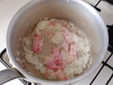 鍋にオリーブオイルを入れて弱火にかけ、玉ねぎを炒める。しんなりしてきたらベーコンを加え、さらに炒める。