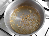 鍋にニンニクのみじん切りとオリーブオイルを入れ、弱火にかける。