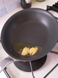フライパンにオリーブオイルを大さじ1入れ、潰したにんにくと一緒に弱火にかける。にんにくの表面が茶色くなってきたら、ベーコン、ごぼうを加え、弱火で炒める。